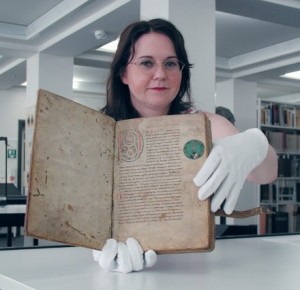 Bibliothecaresse toont een van de oeroude handschriften van het Nibelungenlied.